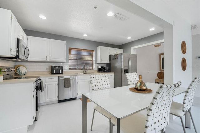 kitchen featuring a sink, white cabinetry, appliances with stainless steel finishes, and light countertops