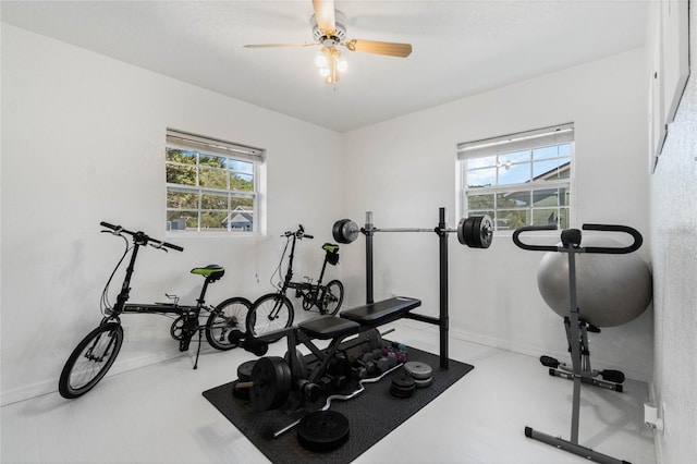 exercise area featuring a wealth of natural light, baseboards, and ceiling fan