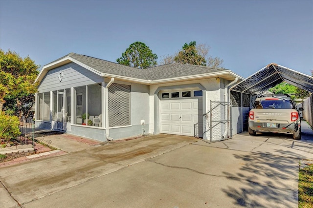 view of front of property featuring driveway, a sunroom, a shingled roof, a garage, and a carport