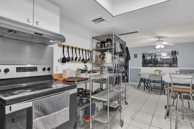 kitchen with visible vents, electric stove, under cabinet range hood, light tile patterned flooring, and ceiling fan