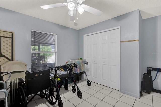 interior space with light tile patterned floors, a closet, and ceiling fan