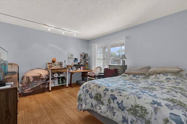 bedroom with light wood-style flooring and a textured ceiling