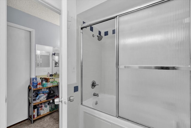 full bathroom with combined bath / shower with glass door and a textured ceiling