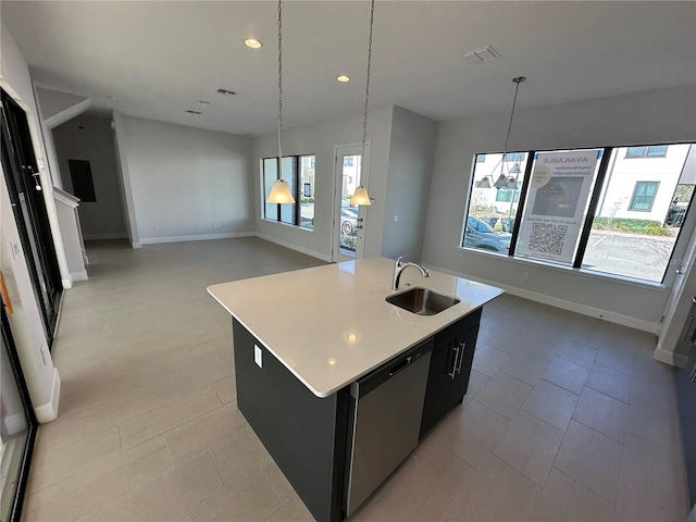 kitchen with open floor plan, dishwasher, light countertops, an island with sink, and a sink