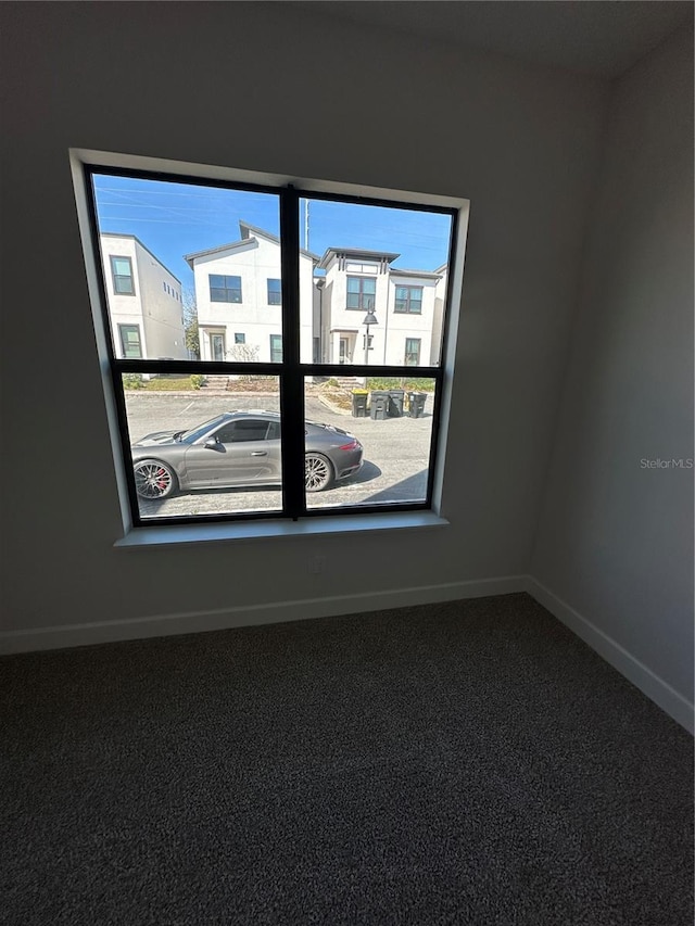 empty room with baseboards and carpet