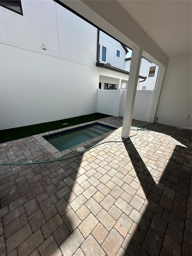 view of swimming pool with a patio and fence