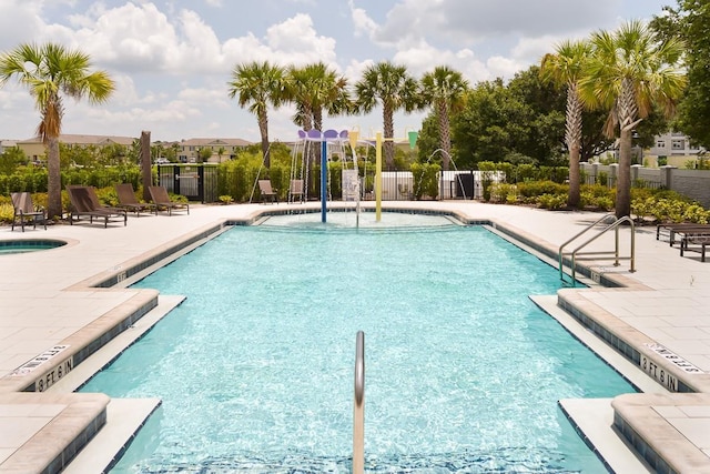 pool with a patio area and fence