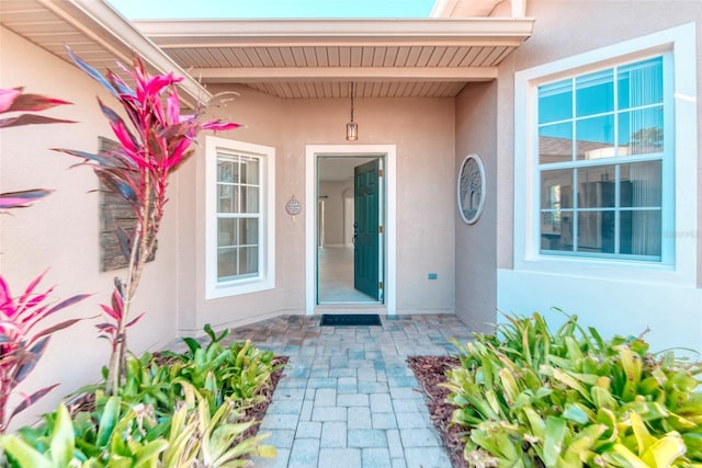 doorway to property featuring stucco siding