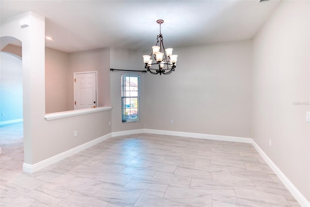 unfurnished room with arched walkways, a notable chandelier, and baseboards