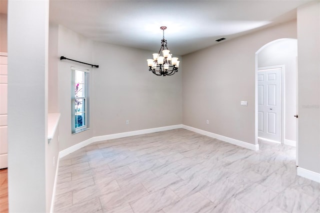 empty room with visible vents, baseboards, an inviting chandelier, arched walkways, and marble finish floor