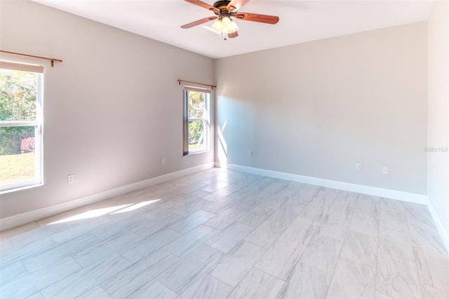 spare room featuring baseboards and a ceiling fan