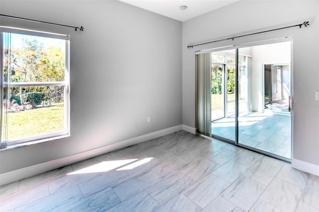 spare room with baseboards and marble finish floor