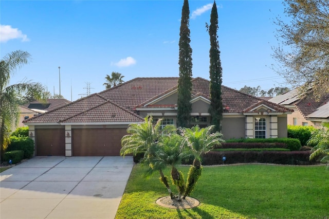 view of front of property with a front lawn, a tiled roof, concrete driveway, stucco siding, and a garage