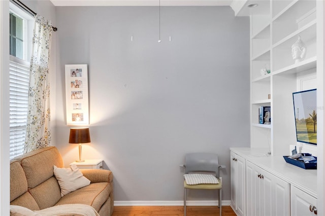 sitting room featuring a wealth of natural light, light wood-style flooring, and baseboards