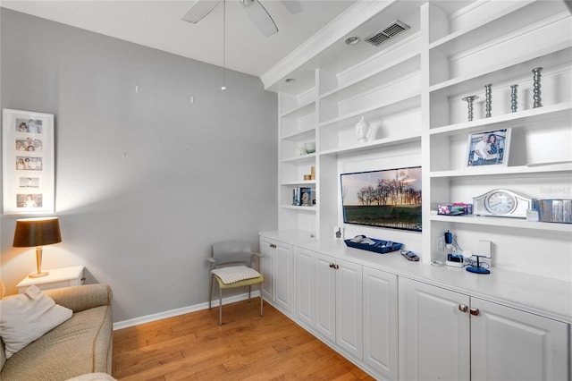 interior space featuring a ceiling fan, baseboards, visible vents, and light wood finished floors