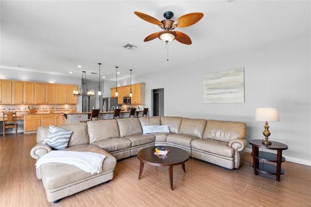 living room featuring light wood finished floors, visible vents, baseboards, recessed lighting, and a ceiling fan