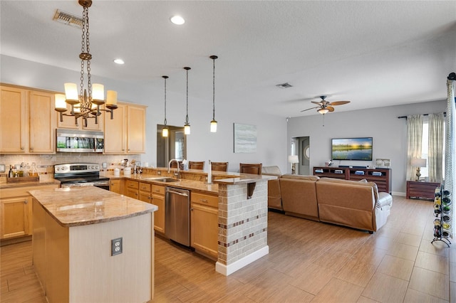 kitchen featuring light brown cabinetry, visible vents, appliances with stainless steel finishes, and a sink