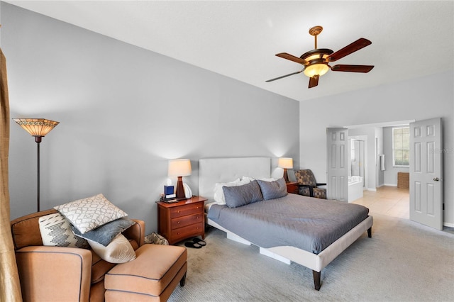 bedroom featuring connected bathroom, light colored carpet, baseboards, and ceiling fan