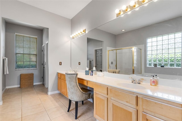 bathroom with tile patterned flooring, a shower stall, baseboards, double vanity, and a sink