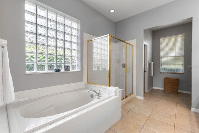 full bathroom featuring tile patterned flooring, a shower stall, baseboards, and a garden tub