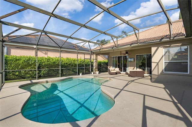 pool featuring glass enclosure, a patio area, and a ceiling fan