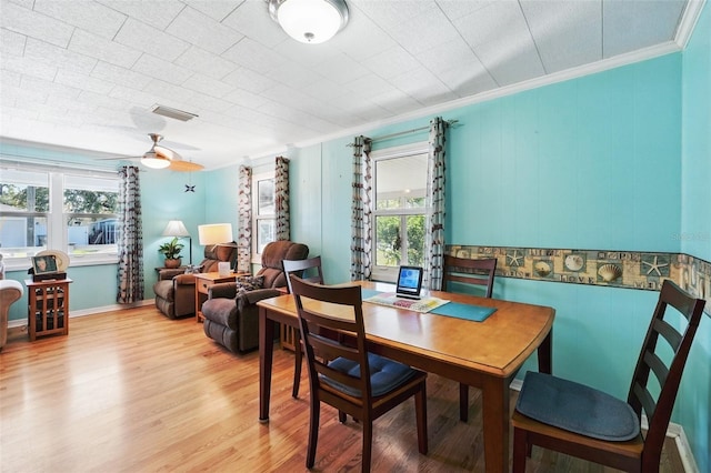 dining space featuring light wood-type flooring, visible vents, ceiling fan, and crown molding