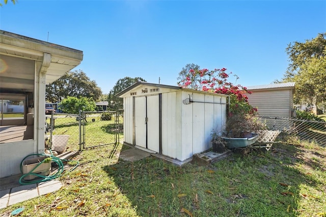 view of shed with fence and a gate