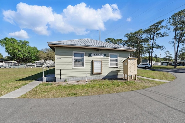 view of front of house featuring a front yard and metal roof