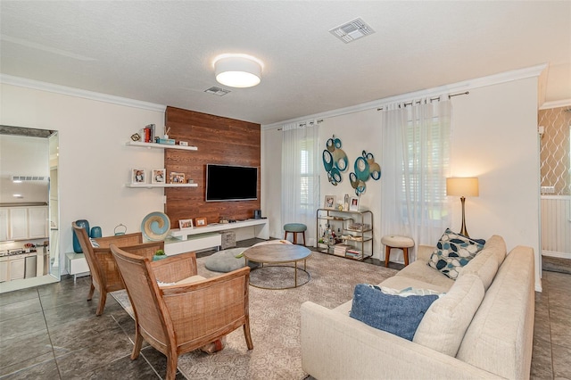 living room featuring crown molding, visible vents, and wood walls