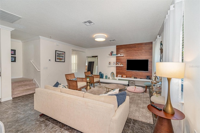 living room with visible vents, a textured ceiling, and wooden walls