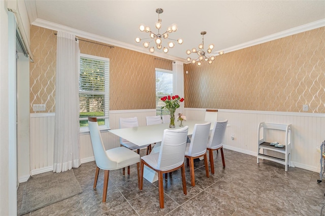 dining room with wallpapered walls, ornamental molding, wainscoting, and a chandelier