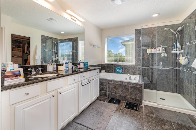 full bath with a sink, a garden tub, double vanity, and a shower stall