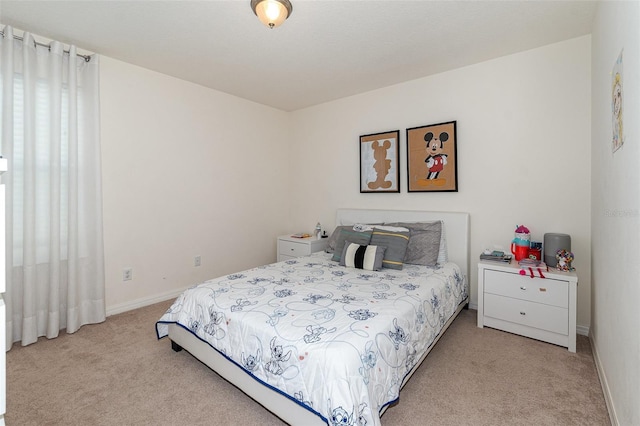 bedroom with baseboards and light carpet