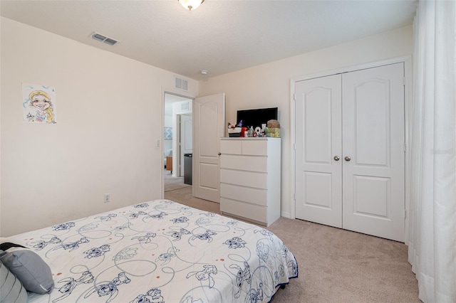 bedroom with light colored carpet, visible vents, and a closet