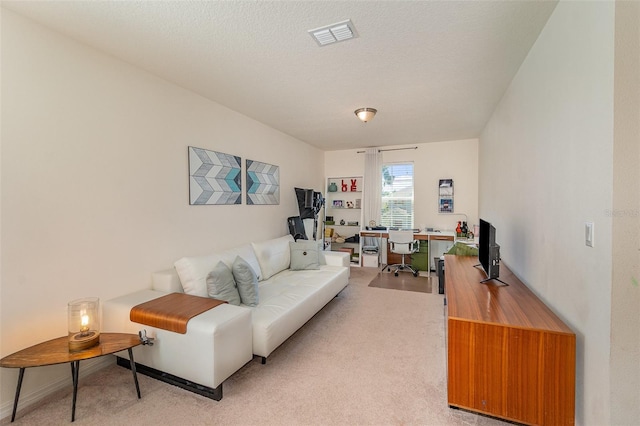 living area featuring visible vents, light colored carpet, and a textured ceiling