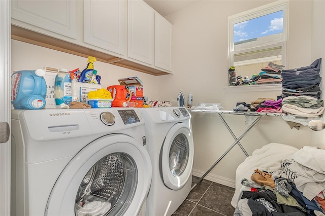 washroom with washer and dryer, cabinet space, and dark tile patterned flooring