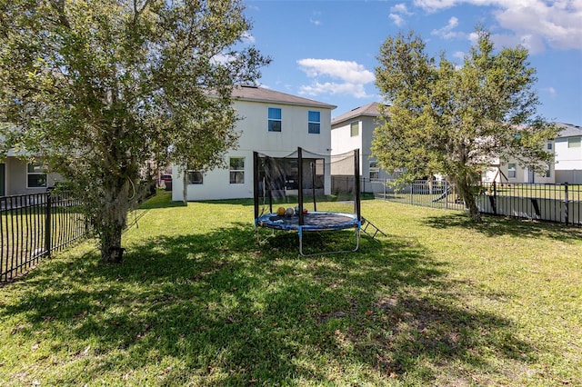 view of yard with a trampoline and a fenced backyard