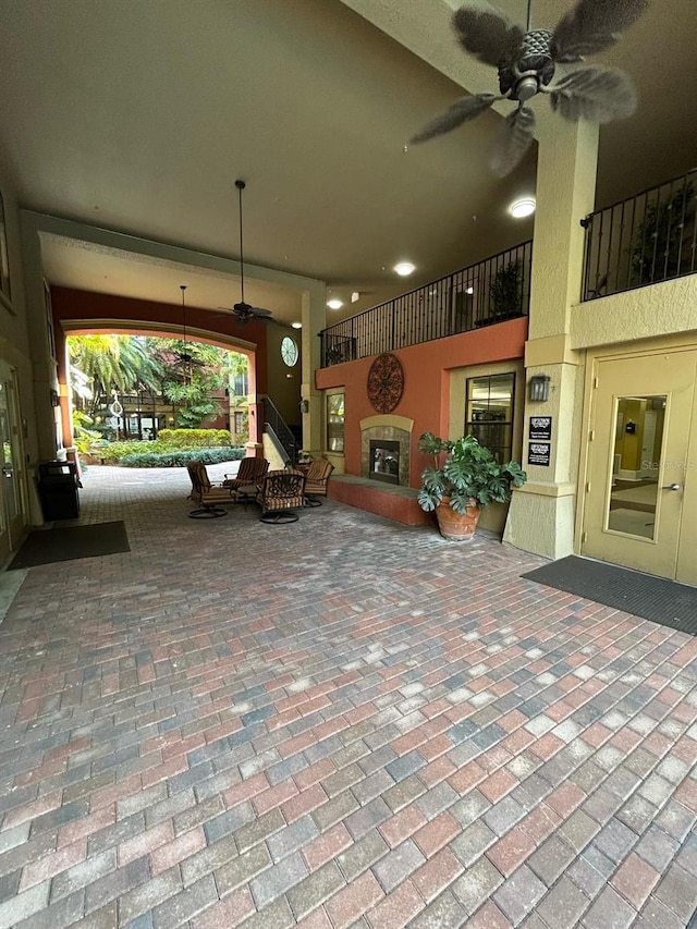 view of patio / terrace with a glass covered fireplace and ceiling fan