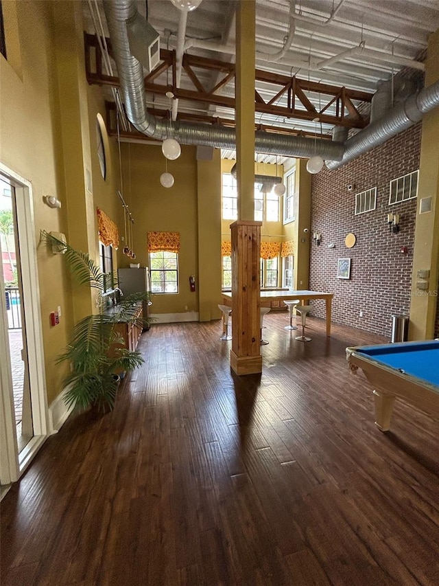 recreation room with pool table, baseboards, a towering ceiling, and wood finished floors