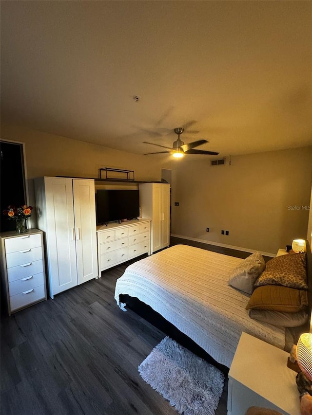 unfurnished bedroom with a ceiling fan, dark wood-style floors, and visible vents