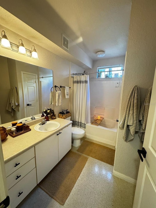 full bathroom with toilet, shower / bath combo, vanity, and a textured wall