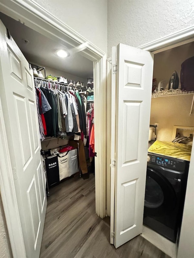 laundry area featuring washer / clothes dryer, wood finished floors, and a textured wall