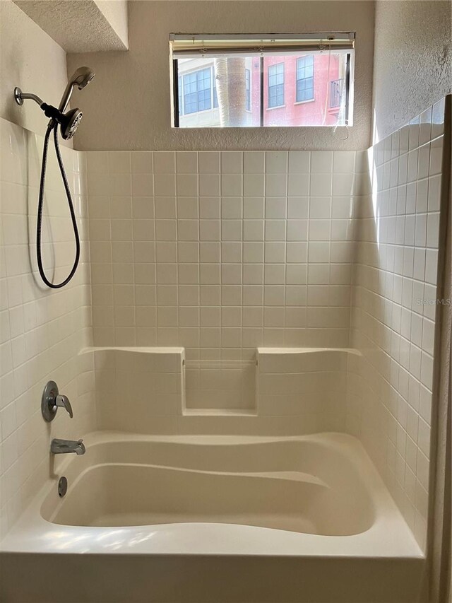 911 N Orange Ave Unit 142, Orlando, FL 32801 - bathroom featuring healthy amount of natural light, shower / washtub combination, and a textured wall