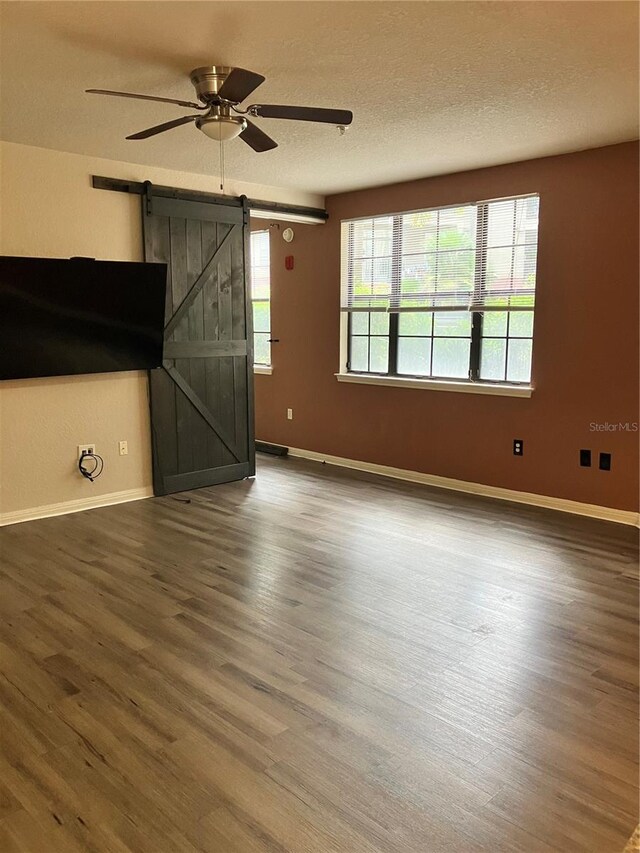 911 N Orange Ave Unit 142, Orlando, FL 32801 - unfurnished living room with a ceiling fan, wood finished floors, a barn door, baseboards, and a textured ceiling