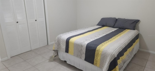 tiled bedroom featuring a closet and baseboards