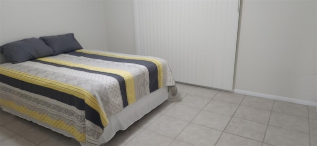 bedroom featuring light tile patterned floors and baseboards