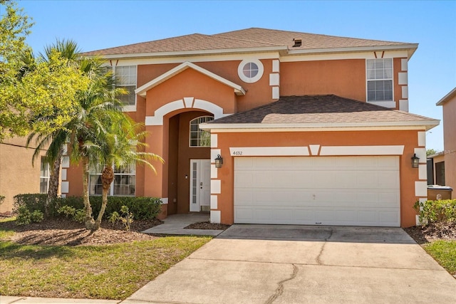 traditional home with a shingled roof, a garage, driveway, and stucco siding