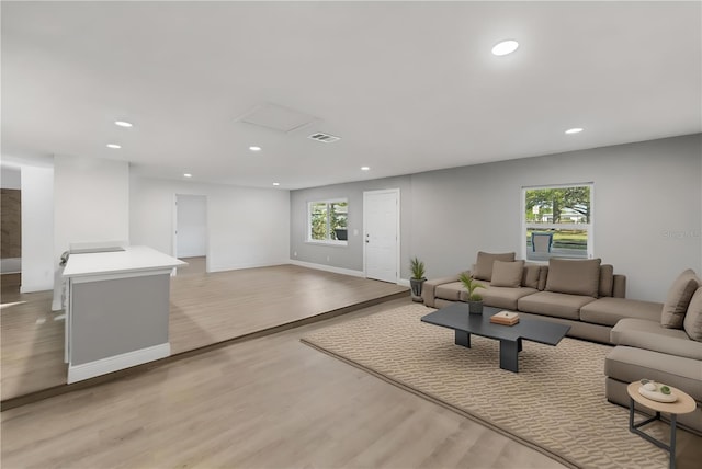 living room with visible vents, recessed lighting, light wood-type flooring, and baseboards