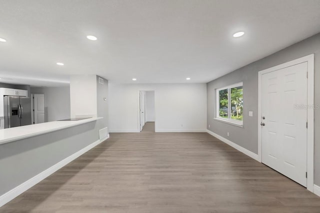 interior space with light wood finished floors, recessed lighting, and baseboards