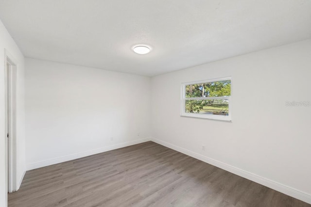 unfurnished room featuring baseboards and wood finished floors